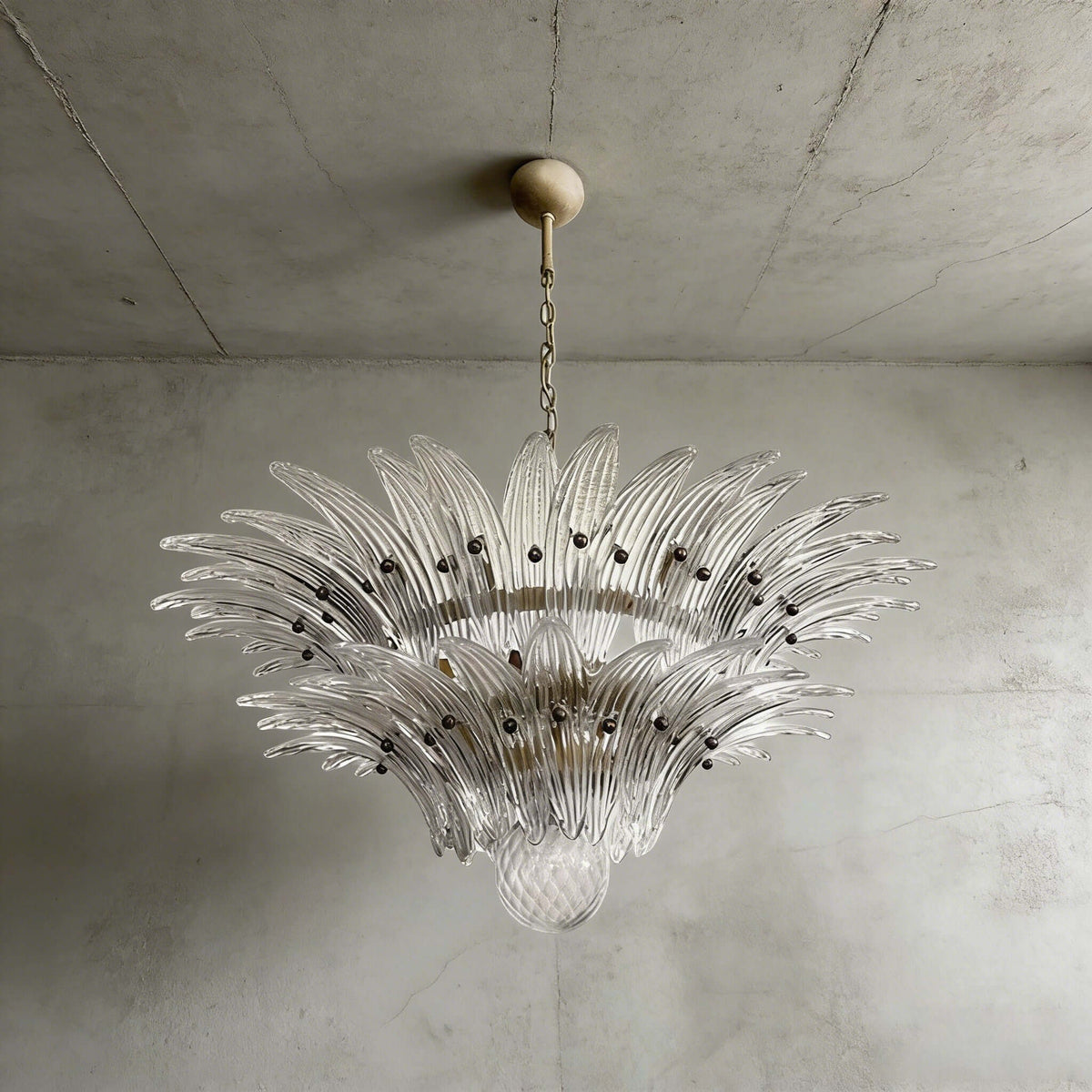 Clear glass Palmette chandelier shown in a compact studio view on a gray wall.
