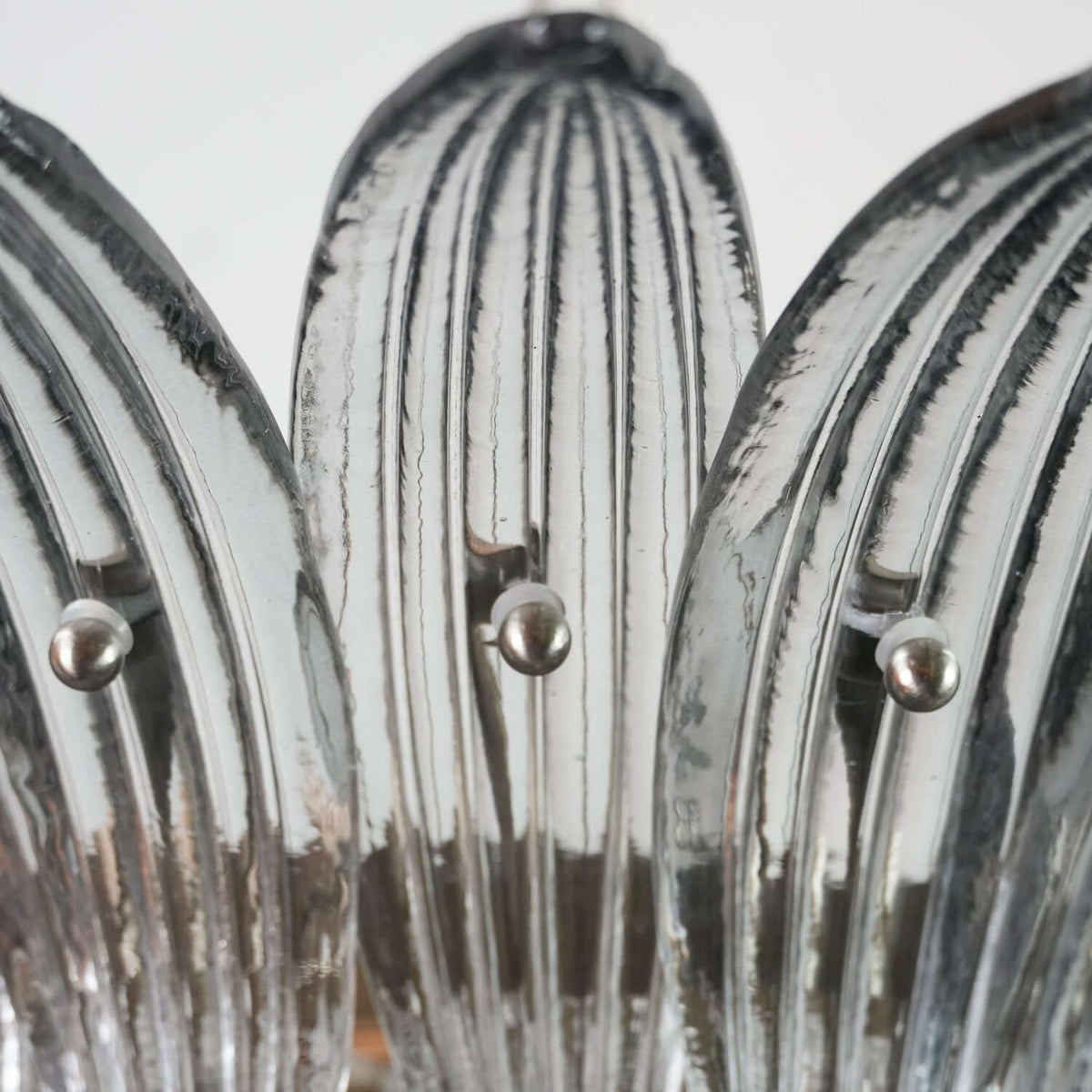 Close-up of clear ribbed glass leaves on the Murano Palmette chandelier.