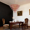 Pink glass chandelier hanging over a dark wood dining table.